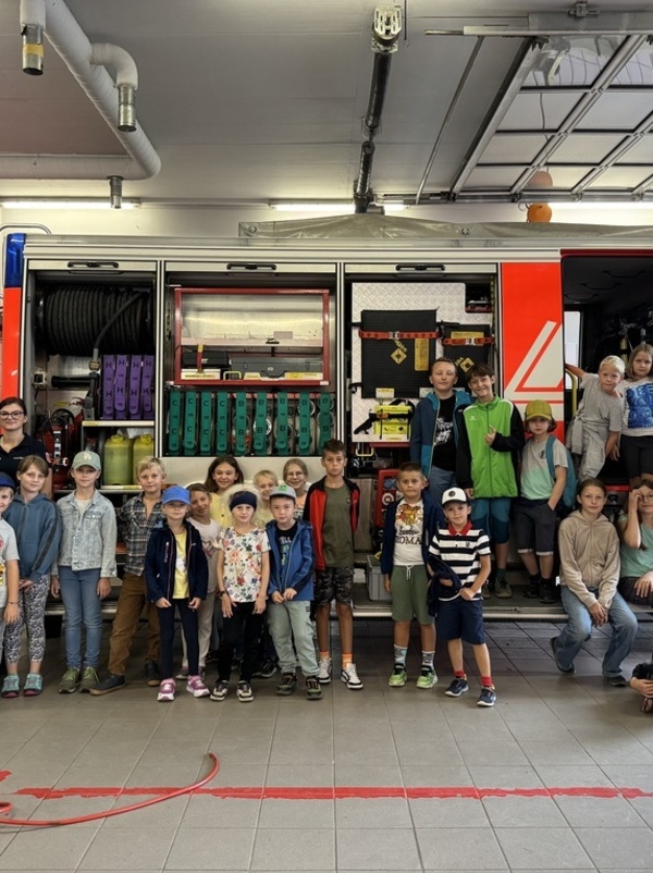 Eine Gruppe von Kindern, die vor einem Feuerwehrauto stehen