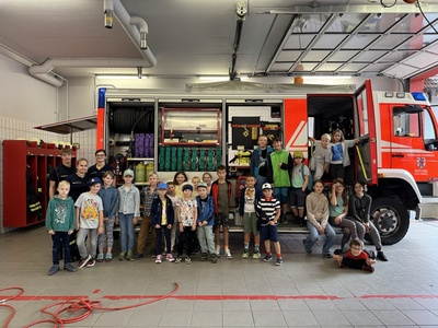 Eine Gruppe von Kindern, die vor einem Feuerwehrauto stehen